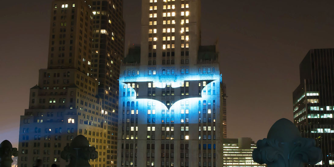 batman logo aka bat signal projected onto a building in Manhattan